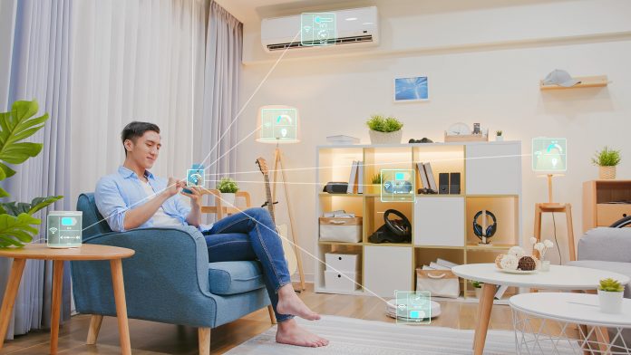 Man using smartphone to control connected smart home devices.